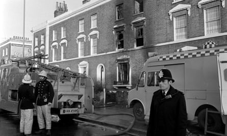 Firefighters and police in front of the fire-ravaged house in New Cross Road, Deptford, south London