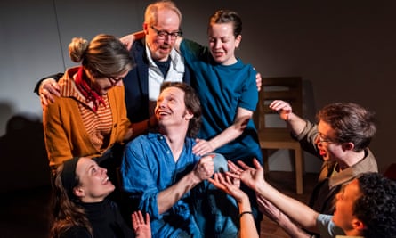 A seated Alfie Friedman surrounded by cast members.