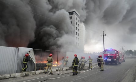 Firefighters work to extinguish a fire at a damaged logistic center after shelling in Kyiv, Ukraine, on Thursday.