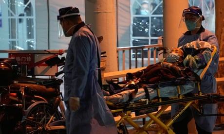 Medical staff move a patient into a fever clinic at a hospital in Shanghai as Covid-19 outbreaks continue
