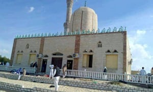 People walk outside a mosque that was attacked in the northern city of Arish, Sinai Peninsula.