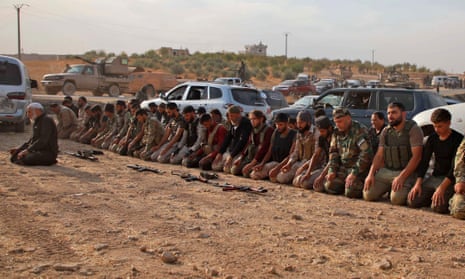 Turkey-backed Syrian fighters kneel to pray as they gather near the village of Qirata on the outskirts of the Manbij.