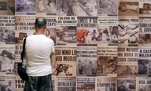 A visitor looks at newspaper covers made by Mexican photographer Enrique Metinides at an exhibition.