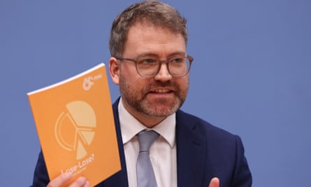 Director of research and policy for the Munich Security Conference, Tobias Bunde, holds a copy of its 2024 report.