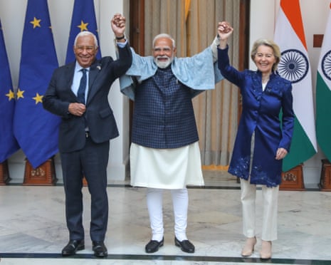 Narendra Modi (centre) raising his arms together with Ursula von der Leyen (right) and the European Council president, António Costa.