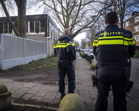 Two Dutch police officers stand guardian outside a Jewish school in Amsterdam