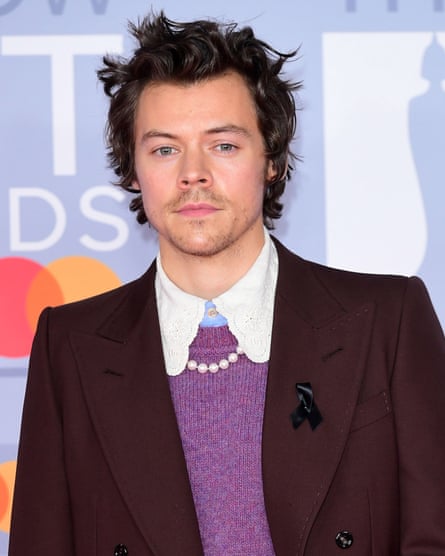Harry Styles wearing a pearl-style necklace under a shirt with frilly collars
