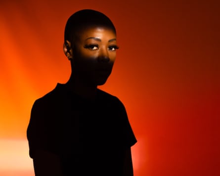 Amahle-Imvelo Jaxa against an orange background, with her eyes visible and the rest of her in shadow