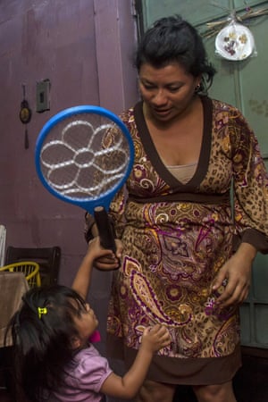 Two-year-old Alejandra is given a mosquito zapper by her pregnant mother, Guadalupe Urquilla, at their home in San Salvador. Urquilla scrubs out the family’s concrete water tank every three days and is desperate for the city’s officials to fumigate the public housing complex where she lives
