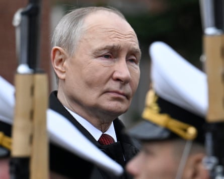 President Vladimir Putin looks on as soldiers walk by