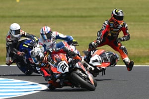A motorbike rider is airborne as he crashes his bike during a race at the Phillip Island Grand Prix, while three other riders move around the corner