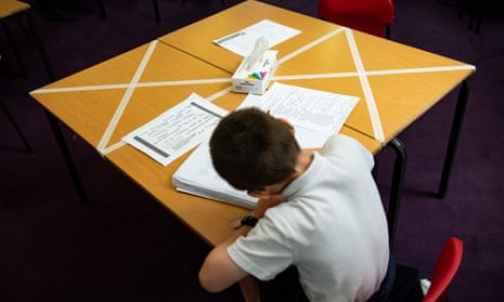 Child working at a table, with seats taped off for social distancing