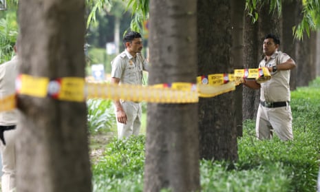 Indian police officers put tape round trees.