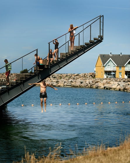 Man jumping in the water from stairs at Hasle Harbour Bath, Bornholm