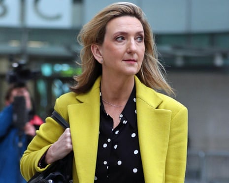 Victoria Derbyshire in a yellow coat walks outside BBC Broadcasting House in London