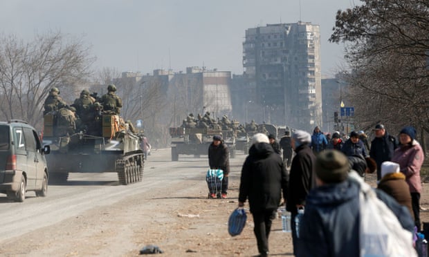 Service members of pro-Russian troops are seen atop of armoured vehicles in the besieged Ukrainian city of Mariupol.