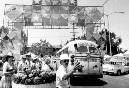 A black and white image of a school bus arrives at a stadium