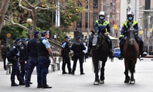 NSW police patrol George Street in front of the Sydney Town Hall in anticipation of an anti-lockdown rally