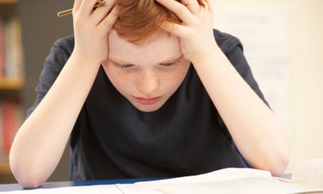 child looking stressed over paper on a desk