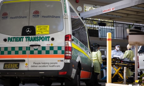 Ambulance attendants wearing full protective clothing prepare a gurney to transport aged care home residents to hospital in Sydney