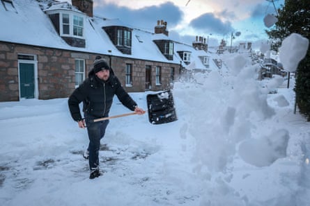 A man with a shovel moves snow in Aberdeen