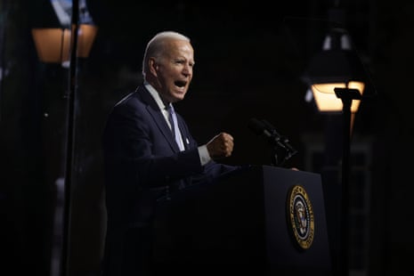 Joe Biden stands at a podium, talking forcefully and striking a fist on the top.
