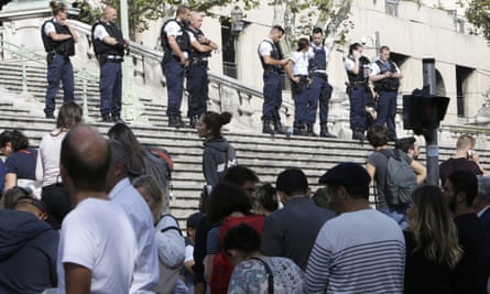 Passengers wait in front of a line of police officers blocking access to Saint-Charles in Marseille