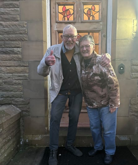 Alison Taylor’s parents with their arms around each other outside a front door