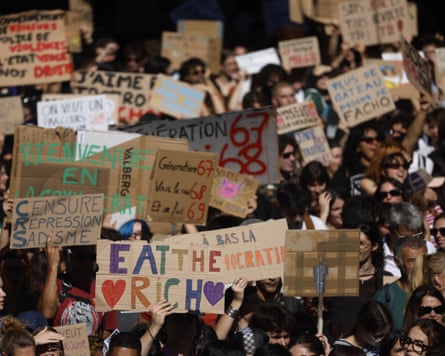 A large crowd of people holding placards including one that says: ‘Eat the rich’