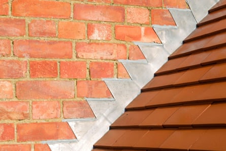 A brick wall with flashing where it meets the roof