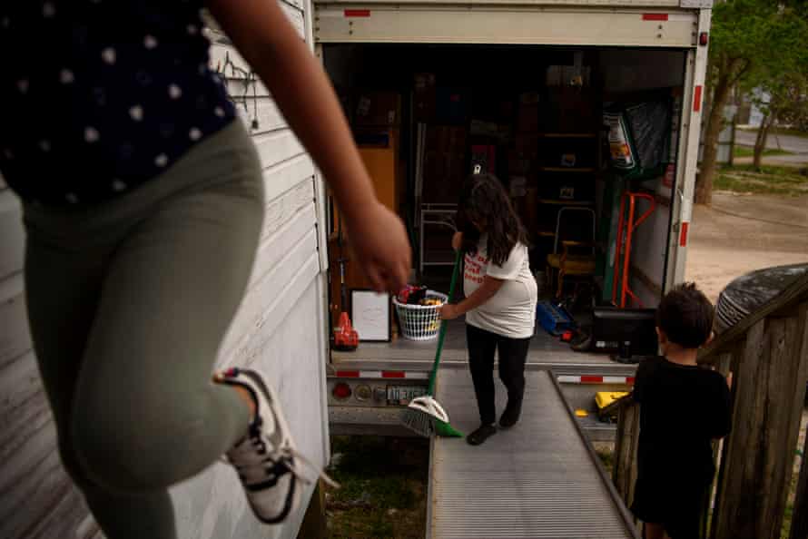 Khloe Aleman, 9, helps her family load a moving van at their home in Houston, Texas, on 29 March. 