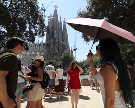 A woman uses an umbrella to protect from the sun during a heatwave in Barcelona