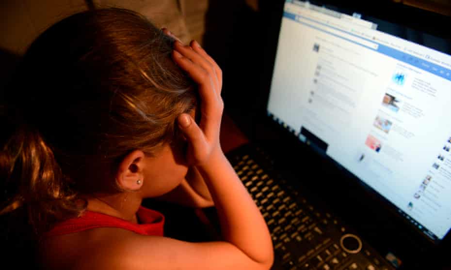 An image depicting an upset girl in front of a laptop.