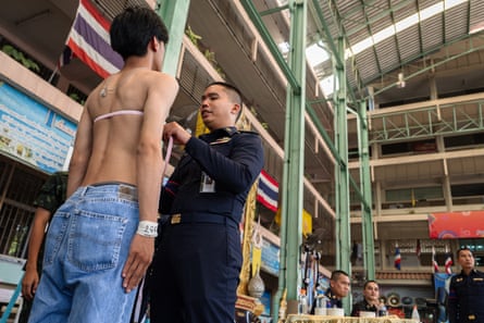 A man has his chest measured before drawing his ballot during the Thai military conscription drawing at Watmatchantikaram School in Bangkok.