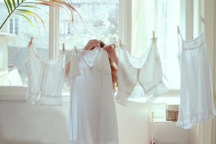 a woman Hanging Clothes on a line at homeGettyImages-1265663681