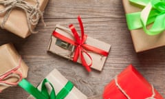 Mousetrap with red ribbon and gift boxes on wooden table