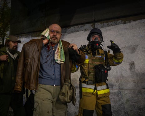 A rescuer helps an injured man after a Russian strike on a residential building in Kyiv, Ukraine, Friday, 10 October 2025