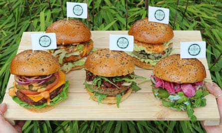 A platter of various vegan burgers with mini flags saying The Vurger Co. in each