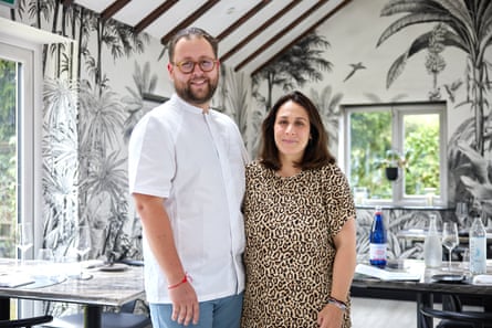 The couple smile for a photo in the restaurant’s dining room