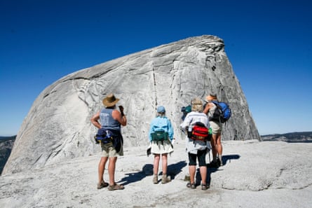 a group of hikers look at a mountain curved like a dome
