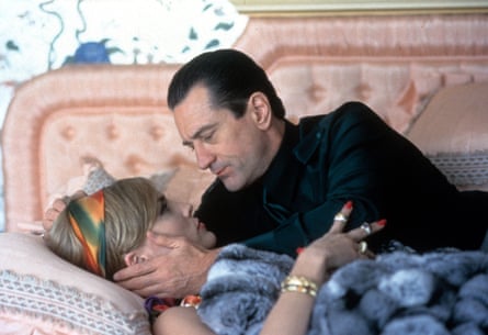 De Niro holds her head tenderly as she lies on a bed