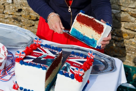A person holds a large slice of cake, which has a union jack and a picture of Winston Churchill on it.