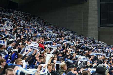 FC Copenhagen hold up their scarves and cheer for their team.