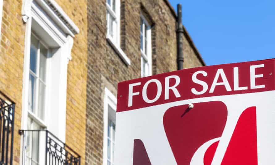 a for sale sign outside a yellow brick Victorian terrace home