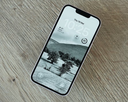 The lockscreen of an iPhone 17e on a wooden table.