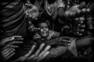 A Rohingya refugee boy cries as he fights his way in the crowd to get food aid from a local NGO at the Balukali refugee camp on 18 September in Cox’s Bazar, Bangladesh, where more half a million Rohingya refugees have fled an offensive by Myanmar’s military