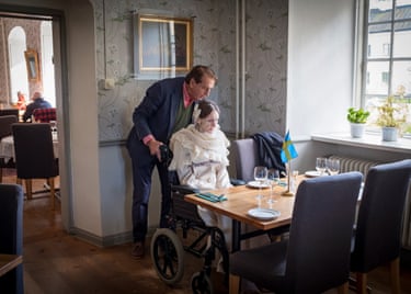 Engla Louise sits in a wheelchair in a restaurant at Löfstad Castle with her father, Hans Ericsson