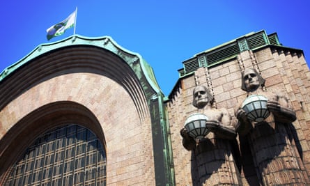 Statues holding spherical lamps at the entrance to Helsinki railway station, Finland