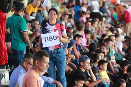 Refugees wait at football stadium