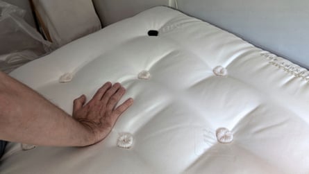 A man’s hand presses into a Millbrook Wool Luxury 4000 Mattress